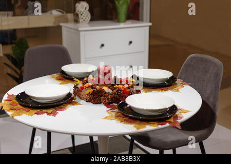 Belle table servi avec les feuilles d'automne les décorations et bougie. Tableau a servi pendant quatre personne pour l'automne le dîner dans le salon. Banque D'Images