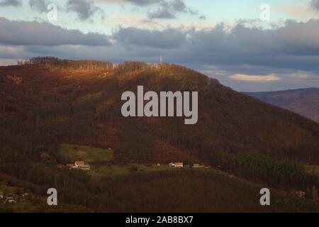 Maisons sous la colline avec la tour de cellules sur le sommet, Slovaquie Banque D'Images