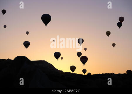 Silhouettes d'un grand nombre de ballons à air chaud contre un ciel soleil Banque D'Images