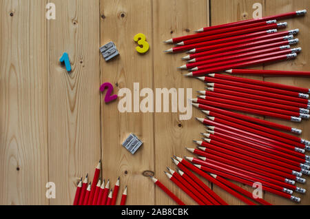 Ensemble de crayons graphite rouge,numéros colorés et shapeners sur fond de bois Banque D'Images