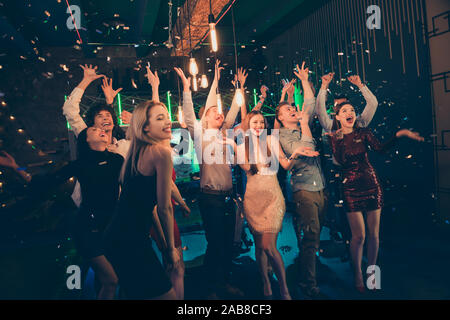 Photo de joyeux cris ravis en extase belle société habillés en soirée détente au club de nuit confetti capture avec des sourires sur leurs Banque D'Images