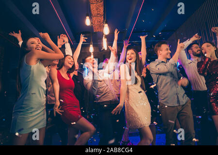 Photo de gens habillés en détente joyeuse soirée ensemble réunis pour passer du temps libre et profiter de leur jeunesse tout en regardant tomber les confettis dans Banque D'Images