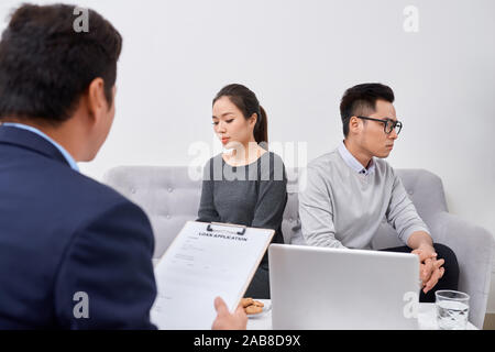 Jeune couple en colère de triché les investisseurs qui détiennent des documents soutenant homme agent immobilier, escroqué des acheteurs de bien protéger leurs droits, trop Banque D'Images