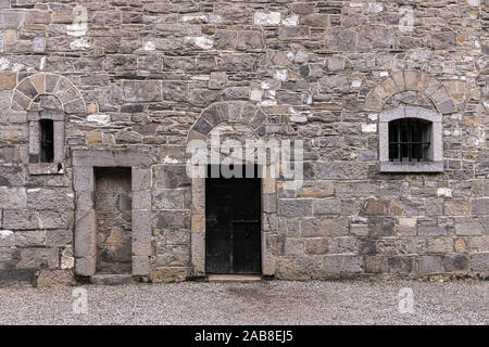 Mur en pierre grise avec porte et windows sur un cour dans la prison de Kilmainham, Dublin, Irlande Banque D'Images