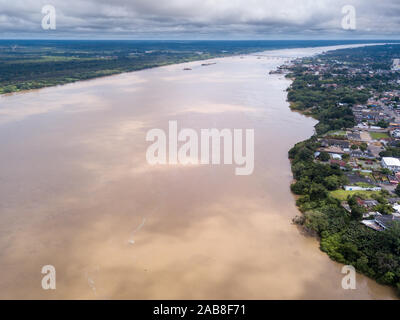 Vue aérienne sur la rivière Madeira, le centre-ville de Porto Velho et la forêt tropicale amazonienne en arrière-plan le jour d'hiver nuageux. Concept d'environnement. Banque D'Images