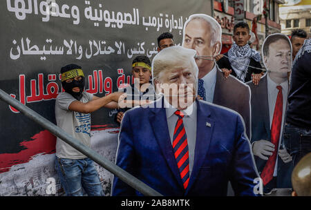 Naplouse, dans les territoires palestiniens. 26 Nov, 2019. Des manifestants palestiniens faites glisser les découpes en carton représentant le président américain, Donald Trump (L), la secrétaire d'Etat américaine Mike Pompeo (R), et le Premier ministre israélien Benjamin Natanyahu, au cours d'une manifestation contre la politique de l'administration d'Atout maj sur les colonies israéliennes dans les territoires palestiniens. Credit : Ayman Nobani/dpa/Alamy Live News Banque D'Images