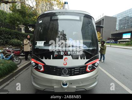 Les résidents locaux chinois voir un 5G et l'auto-Conduite de minibus sur la route dans la ville de Hangzhou, Zhejiang Province de Chine orientale le 26 novembre 2019. Banque D'Images