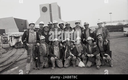 En 1987, un groupe de mineurs s'est réuni pour une photo au-dessus du sol à la mine de charbon Wistow, Selby, North Yorkshire, Angleterre, Royaume-Uni. La production a commencé là-bas en 1983 et a continué jusqu'à ce que les problèmes de mauvaise géologie ont vu la faible production et cela, combiné avec les bas prix du charbon, a vu la mine fermée en mai 2004. Banque D'Images