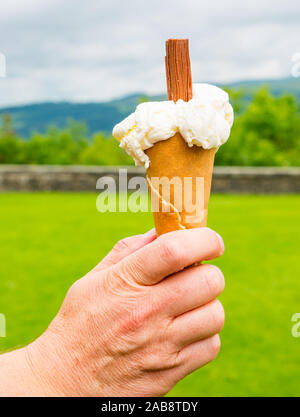 Homme main tenant glace vanille crème glacée, esplanade du château de Stirling, Scotland, UK Banque D'Images