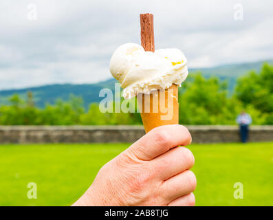 Homme main tenant glace vanille crème glacée, esplanade du château de Stirling, Scotland, UK Banque D'Images