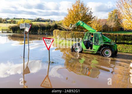 Chargeur chariot roulant dans l'eau de l'inondation de la rivière Severn couvrant les voies dans le village de Vale de Severn Chaceley, Gloucestershire UK 18/11/2019 Banque D'Images