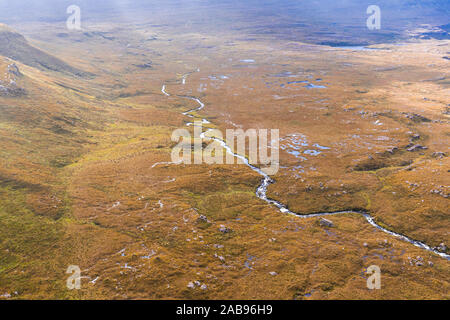 Drone de haute altitude au-dessus de la tige winding river à travers la lande pittoresque près de la montagne Quinag dans le nord-ouest des Highlands d'Écosse - NC500 Vélo Banque D'Images