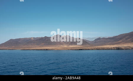 Approche de l'île de Fuerteventura à son point le plus méridional, à Morro Jable avec l'affichage de l'isolement des falaises et des montagnes arides derrière Banque D'Images