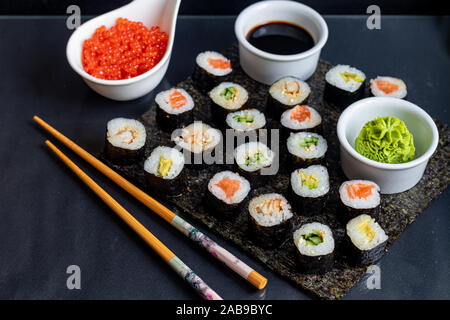 Avec le poisson, Sushi au concombre, à l'anguille, avec de l'avocat. Enveloppé dans d'algue nori. Banque D'Images