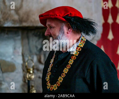 Homme habillé en costume avec chapeau à plumes et de la chaîne d'or en expliquant aux touristes, le château de Stirling, Scotland, UK Banque D'Images