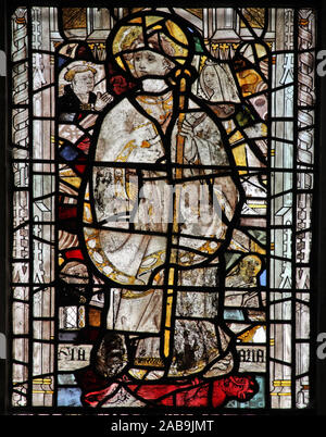 Vitrail médiéval, église de St Andrew, Greystoke, Cumbria, représentant un évêque à onglets portant un alb et chasibule debout sur un diable rouge Banque D'Images