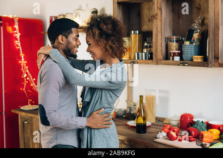 Belle black couple embracing in cuisine confortable Banque D'Images