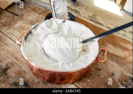 Les oeufs battus et les pommes pour faire des guimauves, les guimauves et la meringue dans un grand bol en cuivre sur une vieille table en bois. Close up. Banque D'Images