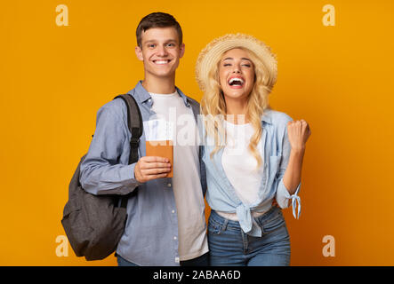 Joyful couple holding passeport avec billets et de célébrer l'obtention des visas Banque D'Images