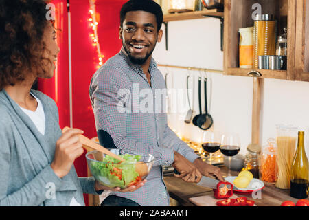 Afro-américain végétarien salade cuisson couple dans la cuisine Banque D'Images