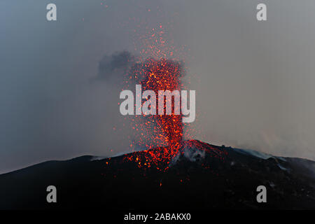 Éruption explosive au crépuscule dans l'un des trois cratères du volcan Stromboli actif, îles éoliennes, Italie. Banque D'Images