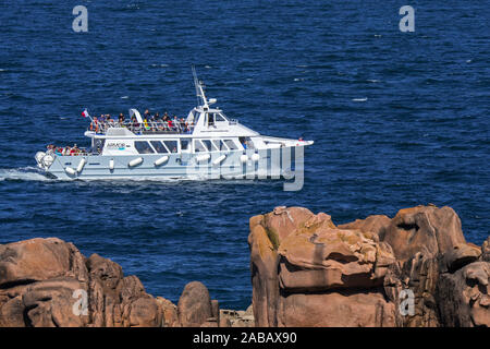 Bateau d'excursion touristique avec voile Navigation Armor le long de la Côte de granit rose / Côte de Granit Rose aux îles de Sept-Îles, Côtes-d'Armor, France Banque D'Images