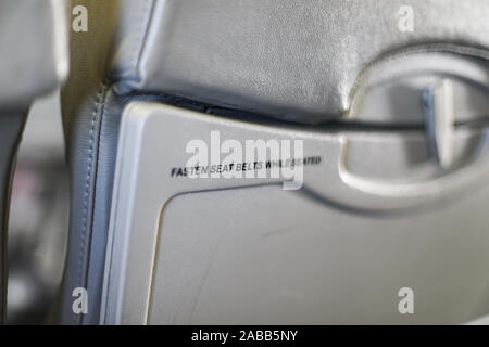 Attacher la ceinture de sécurité en position assise -texte sur plateau de siège d'avion focus sélectif. Copyspace. Copier l'espace. Industrie du voyage. Banque D'Images