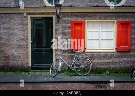 Vélo hollandais traditionnel stationnée sur près de mur de brique à Amsterdam Banque D'Images