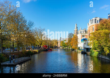 Amsterdam/Pays-Bas - 8 novembre 2019 : Bateaux dans les canaux d'Amsterdam, couleurs d'automne et ciel bleu Banque D'Images