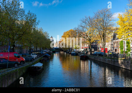 Amsterdam/Pays-Bas - 8 novembre 2019 : Bateaux dans les canaux d'Amsterdam, couleurs d'automne et ciel bleu Banque D'Images