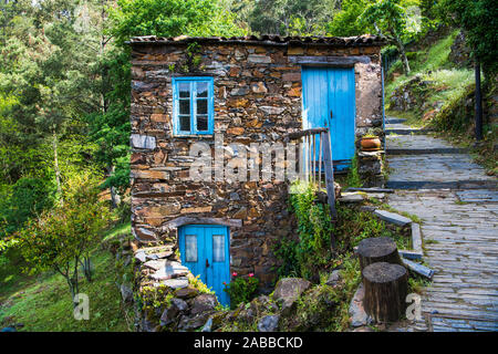 Vieille maison en pierre rustique avec portes et fenêtres en bois bleu dans le village de Cerdeira, Portugal Banque D'Images