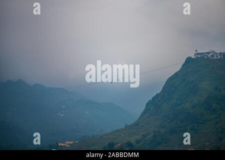 Un téléphérique allant de la ville de Sapa au Vietnam jusqu'à l'indochine montagne tôt le matin avec la brume et nuages dans l'arrière-plan Banque D'Images