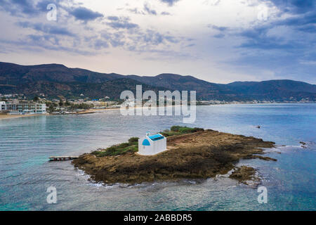 Une vieille église blanche dans une petite île au coucher du soleil à Malia, Crète, Grèce. Banque D'Images