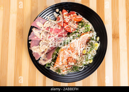 Sashimi de thon et saumon en salade, avec des herbes. Banque D'Images