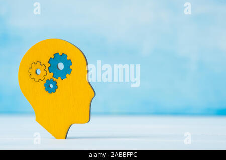 Travaux de cerveau concept. La pensée, la créativité concept de la tête humaine avec des engrenages sur fond bleu Banque D'Images