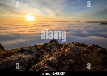 Lever du soleil sur un sommet de montagne avec beaucoup de brouillard et nuages Banque D'Images