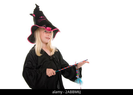 Jeune fille blonde en manteau et un chapeau de sorcière avec baguette. Isolated on white Banque D'Images