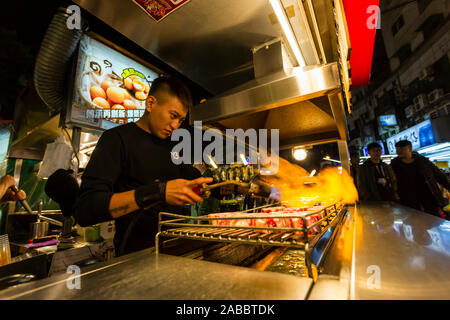 Taoyuan, Taiwan - le 12 novembre 2019 : travail du vendeur et la préparation des aliments dans un street food au marché de nuit de Zhongli situé à Taoyuan, Taiwan. Banque D'Images