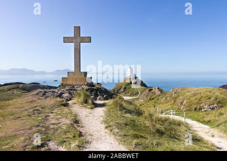 Croix et le phare sur l'île Llanddwyn, Anglesey, Pays de Galles Banque D'Images