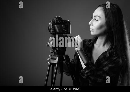 Studio shot of young Beautiful woman hipster vlogging en noir et blanc Banque D'Images