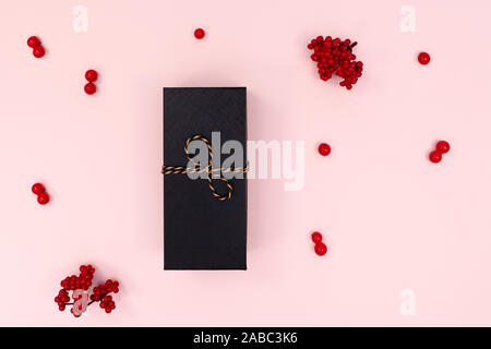 Boîte-cadeau de Noël, rouge cerise sur fond rose. L'hiver, Noël, nouvel an concept. Mise à plat, vue du dessus, copy space Banque D'Images