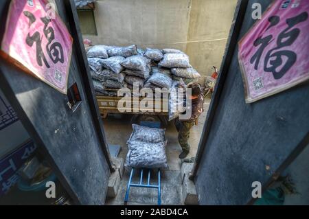 Une suppression du charbon s'emploie à faire des sacs de charbon, au total 10 tonnes chaque jour, aux maisons des habitants vivant à la vieille ville de Jinan City, Shandong en Chine de l'est p Banque D'Images