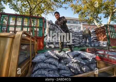 Une suppression du charbon s'emploie à faire des sacs de charbon, au total 10 tonnes chaque jour, aux maisons des habitants vivant à la vieille ville de Jinan City, Shandong en Chine de l'est p Banque D'Images