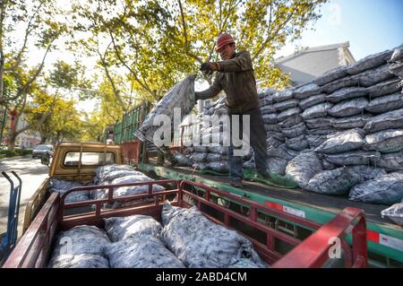 Une suppression du charbon s'emploie à faire des sacs de charbon, au total 10 tonnes chaque jour, aux maisons des habitants vivant à la vieille ville de Jinan City, Shandong en Chine de l'est p Banque D'Images