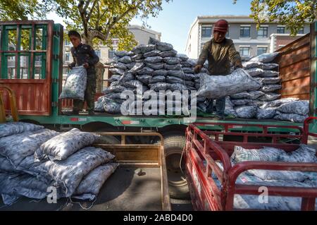 Une suppression du charbon s'emploie à faire des sacs de charbon, au total 10 tonnes chaque jour, aux maisons des habitants vivant à la vieille ville de Jinan City, Shandong en Chine de l'est p Banque D'Images