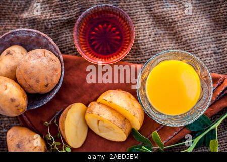 Le visage de jus de pomme de terre pack ou masque de visage dans un bol en verre sur la surface du sac de jute composé de jus de pomme et le miel.Utilisé pour fins de blanchiment de la peau le long de Banque D'Images