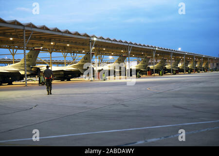 Membre de l'Air National Guard's 149th Fighter Wing marche à travers la ligne de vol lors des opérations de nuit le 21 novembre à Joint Base San Antonio-Lackland, Texas. Le 149e FW est une unité de formation formelle et relèvent de l'éducation et de la formation de l'Air commande. Aujourd'hui, le principe de la mission de l 149e Escadre de chasse est de former des pilotes de F-16 prêts au combat. La première classe de service actif, l'Air National Guard et l'Air Force Reserve pilots a débuté en mai 2000. À ce jour, la 149e Escadre de chasse continue de fournir des compétents et qualifiés, les pilotes de chasse F-16 à des bases à travers le monde. (Air National Guard pho Banque D'Images