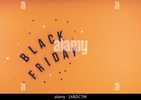 Mots vendredi noir sur un fond orange lumineux avec des paillettes Banque D'Images