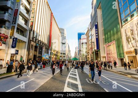 Vue sur la rue le long de la Ginza par Mikimoto et Mitsukoshi magasins le week-end quand il s'agit d'une zone piétonne. Heure d'or. Banque D'Images