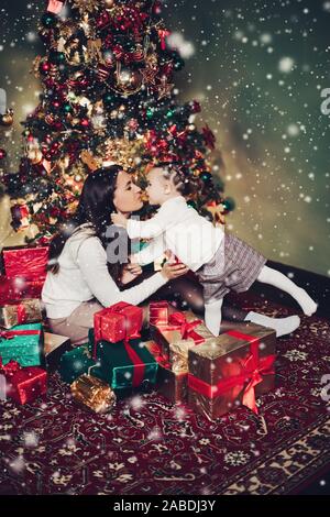 Mother and Daughter hugging in pile de cadeaux. Banque D'Images